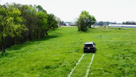Following-A-Driving-Car-On-Green-Meadows-During-Property-Surveillance-Near-Siloam-Spring,-Arkansas,-USA