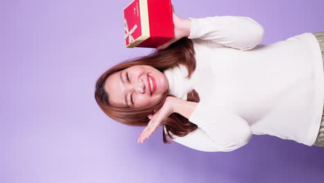 Vertical-Portrait-beautiful-of-Asian-happy-woman-holding-a-red-gift-box-standing-isolated-over-a-violet-background-2