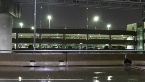 Illuminated-multilevel-car-park-on-a-rainy-night-with-no-people-around