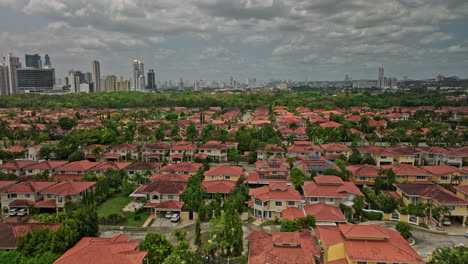 Panama-City-Aerial-v87-low-level-flyover-costa-del-este-neighborhood-capturing-residential-houses-gated-community-with-downtown-cityscape-in-the-background---Shot-with-Mavic-3-Cine---March-2022