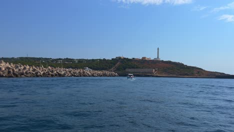 Tour-boat-at-Santa-Maria-di-Leuca-lighthouse-on-Ionian-coast-of-Salento-in-Apulia,-Italy
