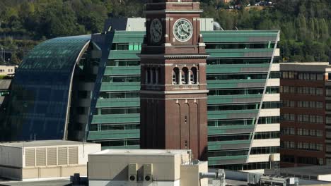 Rising-aerial-shot-revealing-the-King-Street-Station-clock-tower-in-Seattle's-downtown-neighborhood