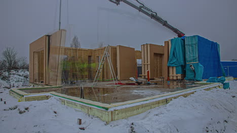 Time-lapse-of-the-construction-of-a-prefabricated-building-assembled-by-a-team-and-a-crane-in-winter