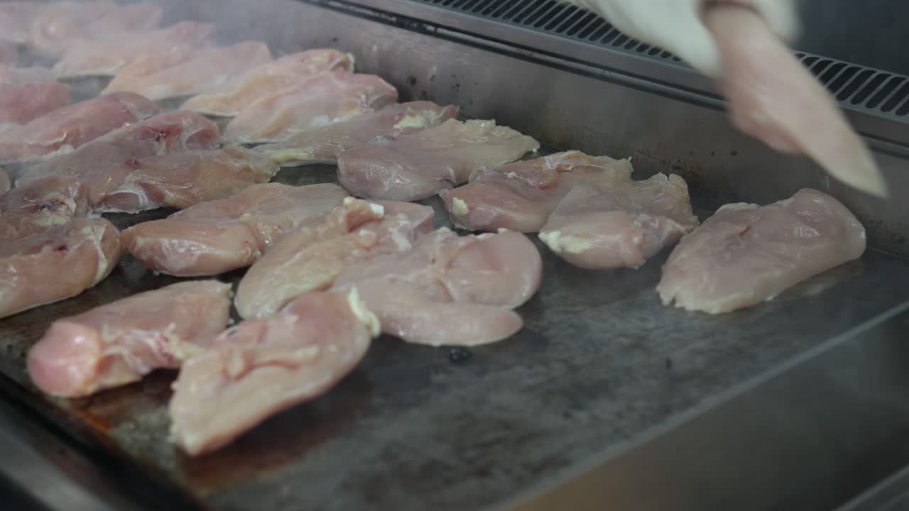 Premium stock video - Chef flipping chicken breasts on the hot grill-3