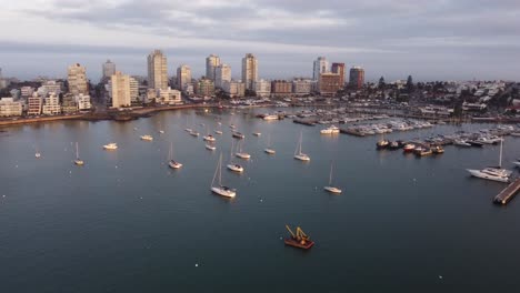 Festgemachte-Segelboote-Im-Hafen-Von-Punta-Del-Este-Mit-Wolkenkratzern-Im-Hintergrund-Bei-Sonnenuntergang,-Uruguay