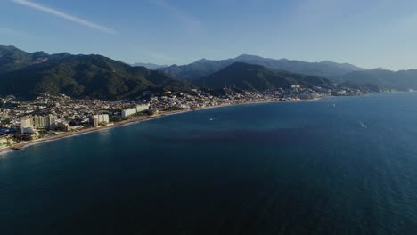 Aerial-view-of-the-coast-of-a-Puerto-Vallarta,-sunny-evening-in-Mexico---tracking,-drone-shot