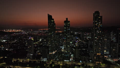 Panama-City-Aerial-v56-cinematic-fly-around-calidonia-neighborhood-capturing-beautiful-cityscape-with-illuminated-buildings-against-orange-radiance-sky-at-dusk---Shot-with-Mavic-3-Cine---March-2022