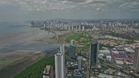 Panama-City-Aerial-v85-flyover-condominiums-along-the-shore-at-costa-del-este-with-pan-american-highway-leading-to-central-district-capturing-downtown-cityscape---Shot-with-Mavic-3-Cine---March-2022
