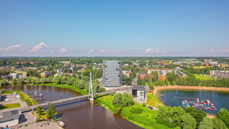 Tartu,-Tartumaa,-Estonia:-High-angle-shot-over-a-bridge-along-a-river-at-a-sunny-day-in-timelapse