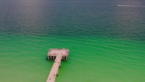 Drone-Footage-of-Beautiful-Pier-with-Green-Blue-Ocean-Waters