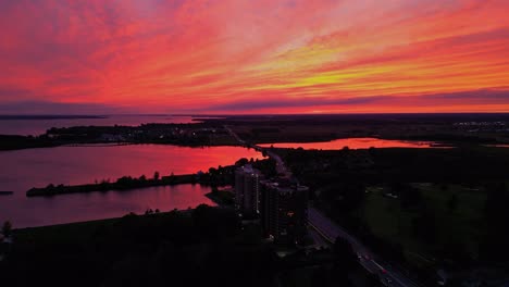 Aerial-Red-sky-sunset-over-looking-apartments-with-waterfront-view