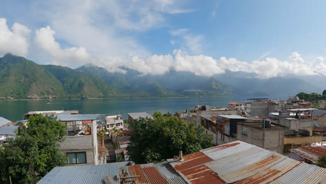 Timelapse-shot-of-residential-houses-on-the-banks-of-lake-Atitlan,-Guatemala,-Central-America-surrounded-by-volcanic-mountains-at-daytime