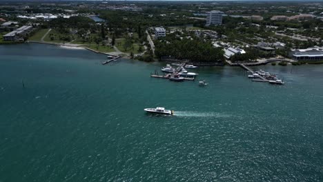 Drohnenaufnahmen-Aus-Der-Luft-über-Dem-Loxahatchee-River-Mit-An-Den-Piers-Festgemachten-Booten-Und-Einem-Vorbeifahrenden-Boot-In-Florida