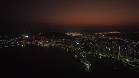Panama-City-Aerial-v58-cinematic-flyover-bay-panning-along-coastal-driveway-capturing-waterfront-high-rise-towers-and-illuminated-downtown-cityscape-at-dusk-night---Shot-with-Mavic-3-Cine---March-2022