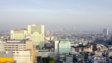 Drone-rising-revealing-great-and-big-city-of-Jakarta-under-air-pollution,-Indonesia