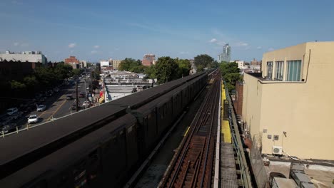 An-aerial-view-of-elevated-train-tracks-with-a-historic-train-travelling-away-from-the-camera-on-a-sunny-day