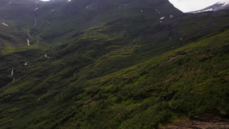 Aerial-view-of-roads,-waterfalls-and-nature-in-Geiranger-valley---panoramic,-drone-shot