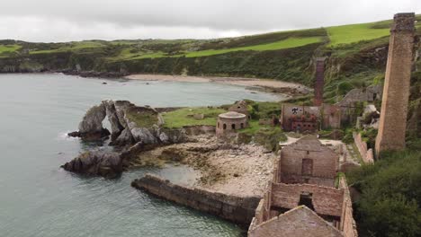 Aerial-view-orbiting-abandoned-remains-of-Victorian-Porth-Wen-industrial-brickwork-factory-in-Anglesey-countryside