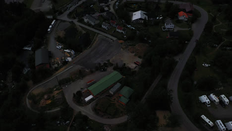 Aerial-view-overlooking-buildings-in-the-Geiranger-village,-gloomy,-evening-in-Norway---tilt,-drone-shot