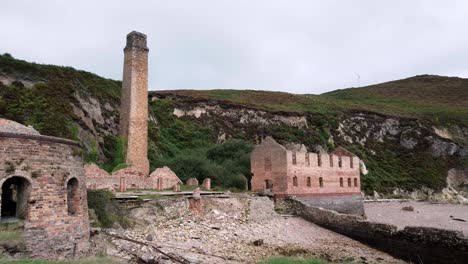 Porth-Wen-Left-Pan-über-Verlassene-Viktorianische-Industrielle-Mauerwerksfabrikreste-An-Der-Erodierten-Küste-Angleseys