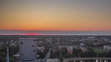 From-one-skyscraper-to-another,-a-daredevil-walks-on-a-tightrope-in-Tartu,-Estonia-at-sunrise---time-lapse