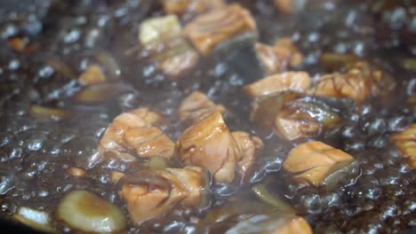 Cinematic-handheld-close-up-shot-of-delicious-Japanese-teriyaki-salmon-fish-simmering-and-bubbling-on-shallow-frying-pan,-reduce-sauce-slowly-with-aromatic-steamy-smokes