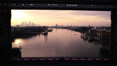 London,-England-UK-at-Sunset,-Revealing-Cinematic-Aerial-View-of-Tower-Bridge,-Thames-River-and-Mist-Above-Cityscape-Skyline