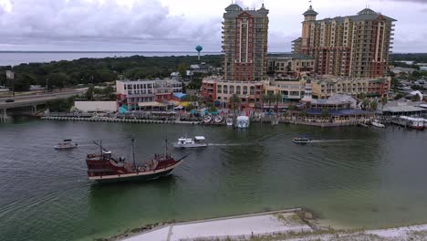 Aerial-view-of-the-Pirate-ship-coming-into-the-Destin-FL-Harbor-and-Harborwalk-Village