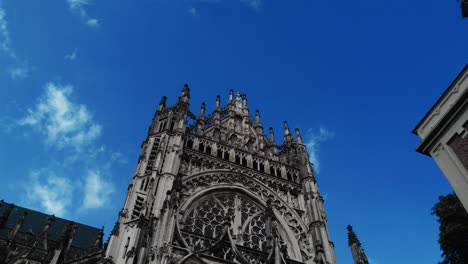 Low-angle-dolly-towards-tower-facade-of-gothic-cathedral-in-s-Hertogenbosch