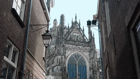 Dolly-through-alleyway-towards-facade-of-gothic-cathedral-in-center-den-Bosch