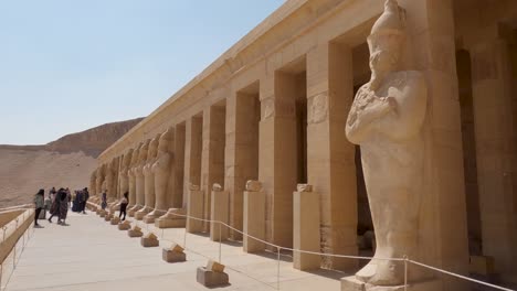 Looking-Across-Row-Of-Colonnade-At-The-Mortuary-Temple-Of-Hatshepsut-On-Sunny-Day-With-Tourists