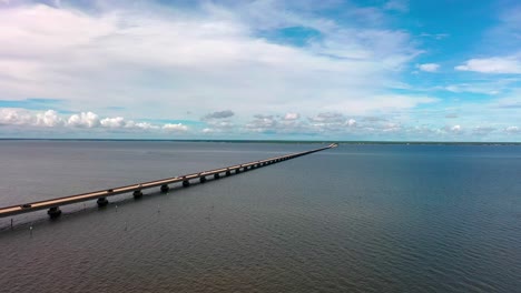 Aerial-view-flying-close-to-the-water-looking-at-the-Mid-Bay-Bridge-connecting-Destin-to-Niceville-Florida