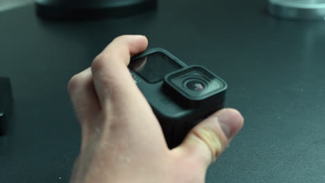 A-filmmaker-holds-an-action-cam-between-his-fingers-with-a-rectangular-lens