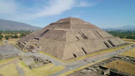 Aerial-view-of-tourists-visiting-the-Teotihuacan-Pyramid-of-the-sun,-in-sunny-San-Juan,-Mexico---circling,-drone-shot
