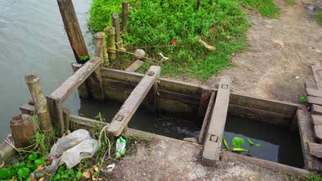 Sluice-Gate,-Water-is-transported-to-the-place-where-fish-farming-is-carried-out,-a-sliding-gate-or-other-device-for-controlling-the-flow-of-water,-especially-one-in-a-lock-gate,-Full-panning-shot