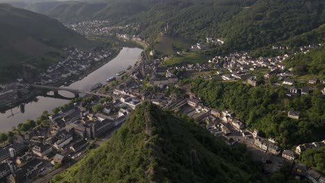 Aerial-Arcing-Shot-Showing-A-Large-Mountain-Peak,-Cochem,-And-Cochem-Castle
