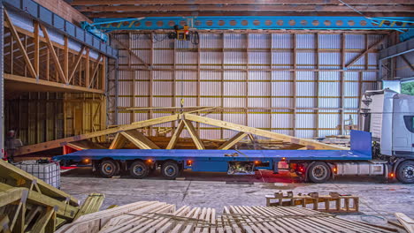At-a-warehouse-loading-prefabricated-roof-trusses-on-a-truck-bed-for-transporting---time-lapse