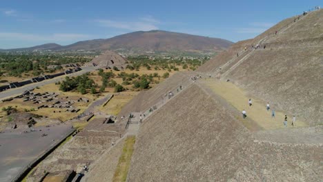 Aerial-view-around-tourists-visiting-the-Pyramid-of-the-sun,-in-sunny-Teotihuacan,-Mexico---circling,-drone-shot