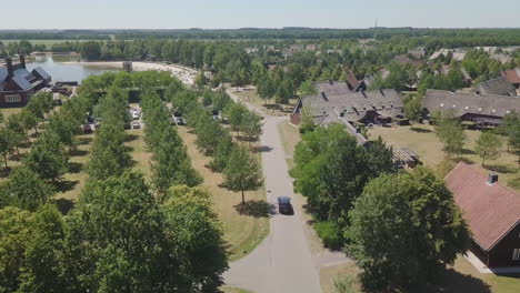 Nice-drone-shot-of-a-black-car-driving-on-a-residential-street-in-the-Netherlands