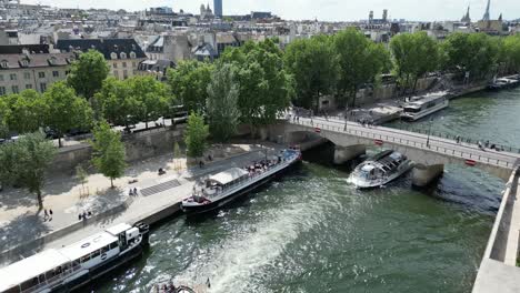 Tourist-boats-sailing-on-Seine-river-passing-under-Archbishop's-Bridge-or-Pont-de-l'ArchevÃªchÃ©,-Paris-1