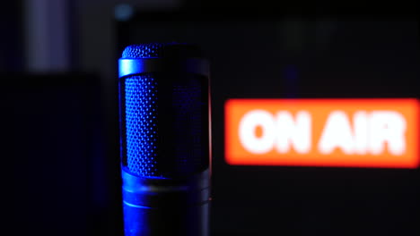 An-on-air-microphone-with-sign-lighting-up-in-a-radio-podcsast-recording-studio