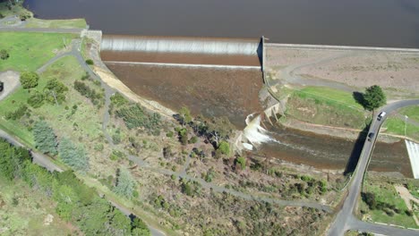 Panning-aerial-view-of-water-spilling-over-the-Upper-Coliban-Reservoir-spillwayl,-central-Victoria,-Australia