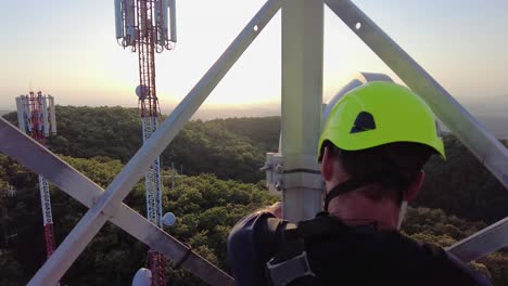 Technician-fixing-the-antennae,-at-top-of-telecom-tower