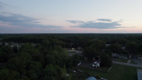 A-drone-shot-of-a-small-town-at-sunset-time-with-yellow-sky-background