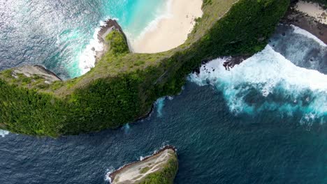 Tall-overgrown-rocky-cliff-and-sandy-beaches-of-Nusa-Penida,-aerial-top-down-view