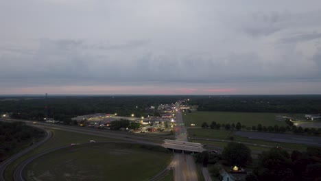 A-drone-shot-of-colored-road-beside-park-with-driving-cars-during-sunset