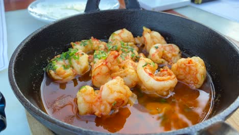 Traditional-Spanish-Gambas-pil-pil-in-a-restaurant-in-Marbella-Spain,-delicious-spicy-shrimp-dish-with-garlic,-4K-shot