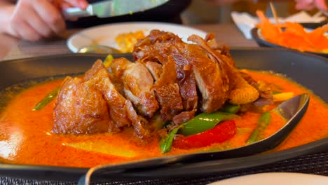Traditional-thai-red-curry-crispy-duck-dish-with-vegetables-in-spicy-sauce,-delicious-Thai-cuisine-restaurant,-4K-shot