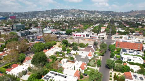 A-suburban-neighborhood-in-West-Hollywood,-California---ascending-aerial-scenic-view-of-the-community-and-foothills