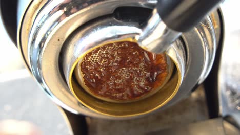 Cinematic-low-angle-close-up-view-capturing-the-channel-from-coffee-extraction,-specialty-single-origin-espresso-extracting-from-the-machine